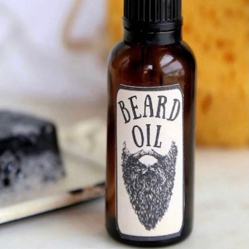 Bottle of beard oil with a label featuring a beard illustration on a blurred background