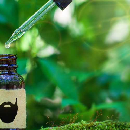 Brown bottle with dropper and green leafy background